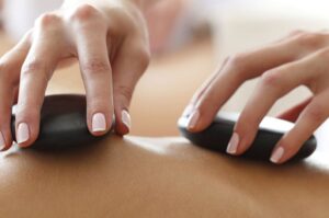 A person receives a hot stone massage at Treetops Spa.