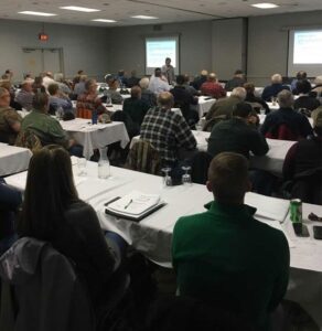 A meeting space at Treetops Resort with white tablecloths and engaged attendees.